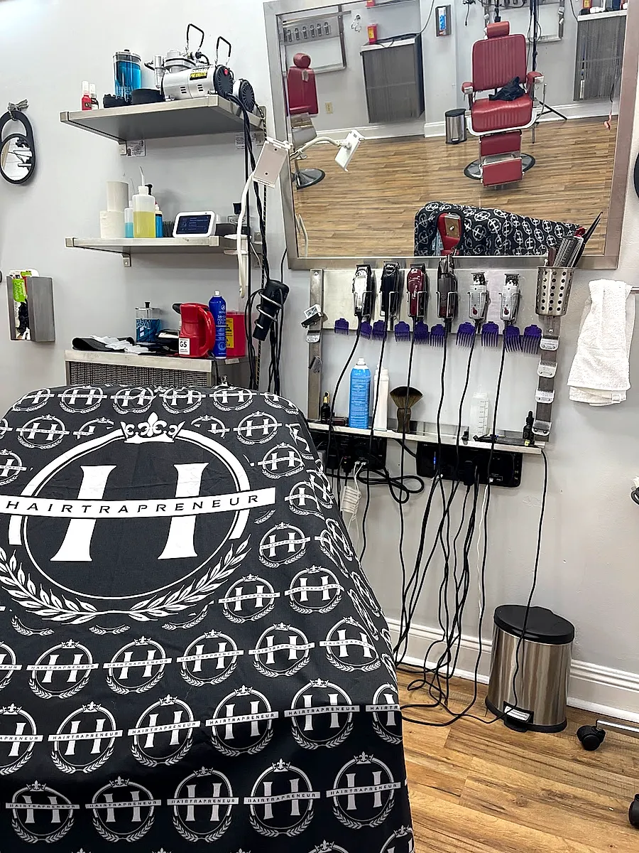 Barber station with the Hairtrapreneur logo cape